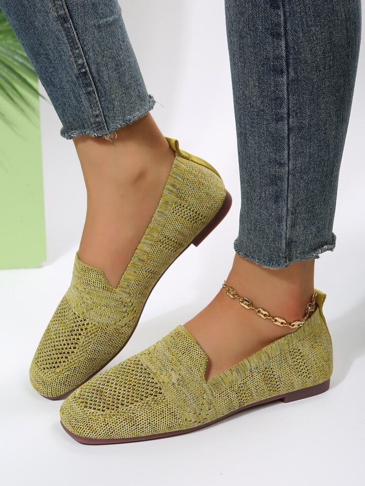Gulgrønne strikkede slip-on sko med hulmønster på model i jeans med guldkæde om anklen. 18