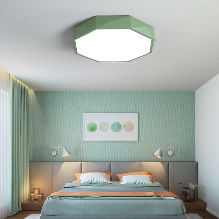 Grøn ottekantet loftlampe over en seng i et soveværelse med grøn væg 20