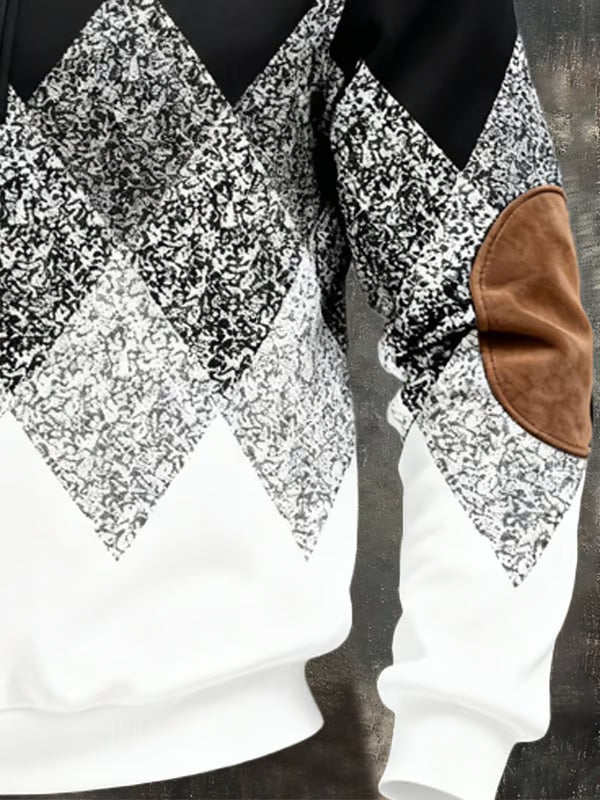 Nærbillede af argyle-mønstret og det brune ruskindslignende albuepatch på ærmet af den sort-hvide pullover 4