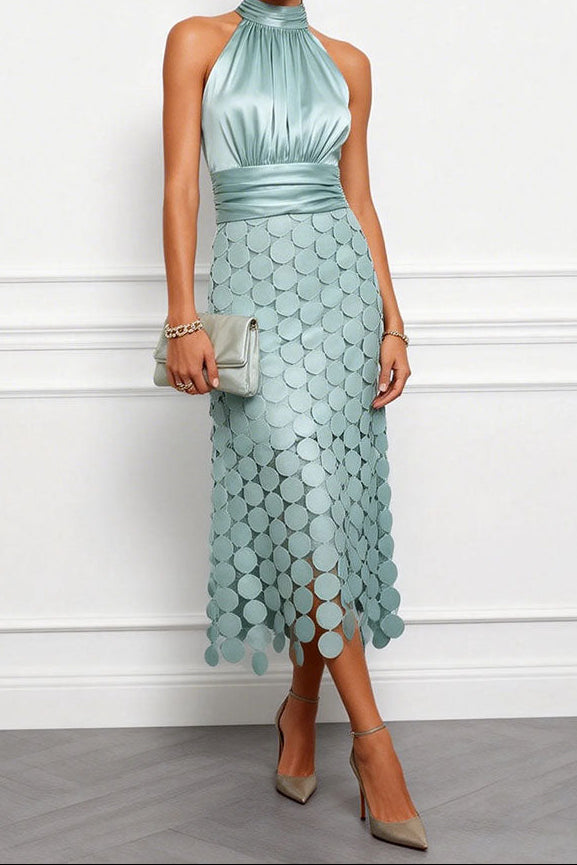 Model i lyst mintgrøn satinkjole med haltertop og skørt af runde skiver, med matchende clutch og grå pumps. 2