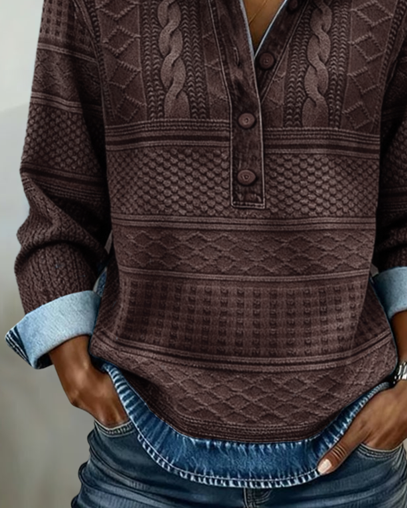 Nærbillede af den brune version med mønstret strik, knaplukning og denimkant forneden, set fra halsudskæring til jeanslinning. 5