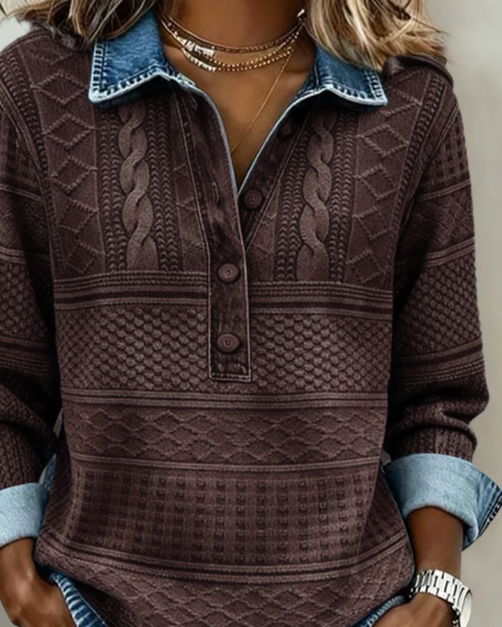 Nærbillede af den brune version med denimkrave, flettet strikmønster og knaplukning på brystet, båret af model med halskæder. 4