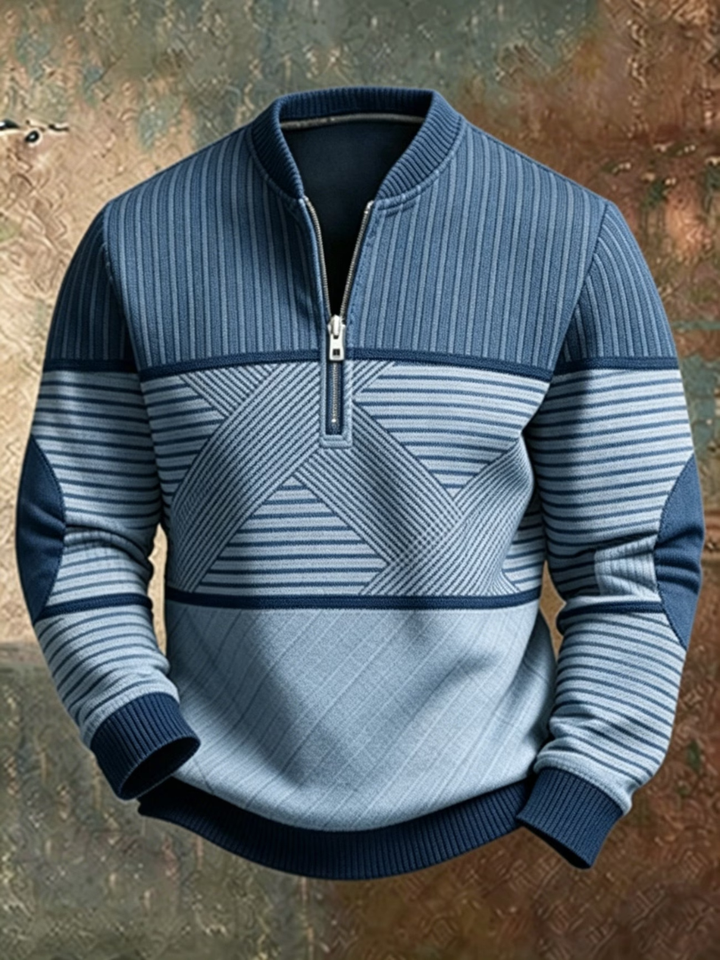 Sweater i blå nuancer med stribet overdel, grafisk mønster på maven og halv lynlås, set forfra mod en rustik baggrund. 3