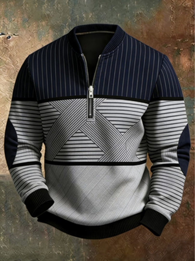 Sweater i marineblå og lysegrå med lodrette og vandrette striber, grafisk X-mønster og halvlynlås, set forfra mod malet baggrund. 1