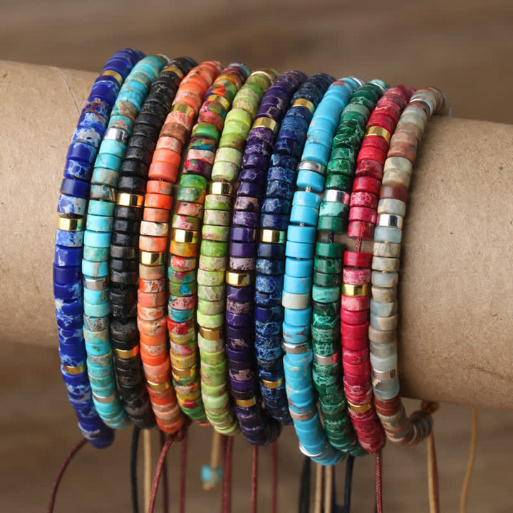 Bunte, handgefertigte Armbänder aus Naturstein, gestapelt auf Kartonrolle, Schmuck, Boho-Stil.
