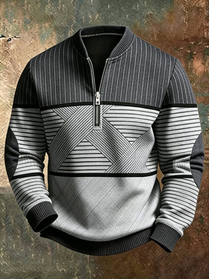 Sweater i mørkegrå og lysegrå med striber, geometrisk mønster over maven og lynlås ved halsen, vist forfra. 2