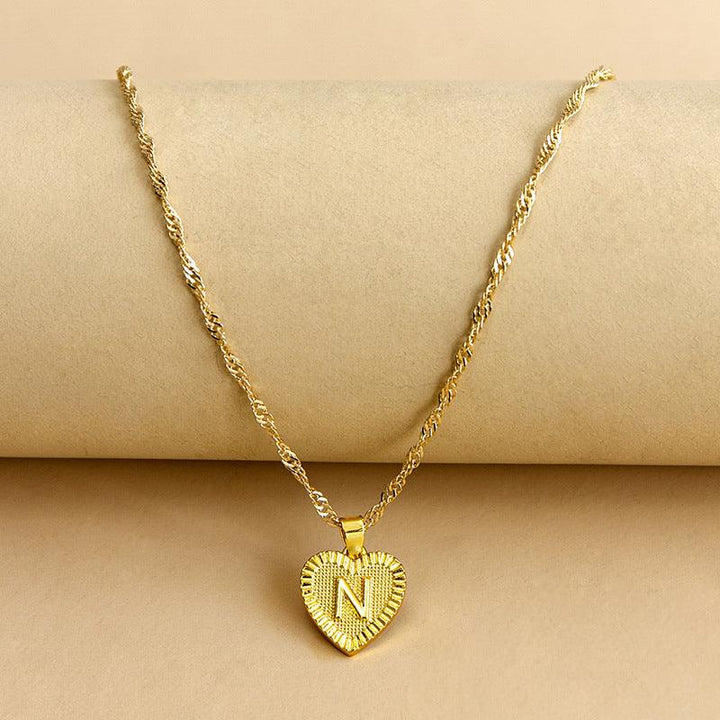 Goldene Herz-Halskette mit Buchstabenanhänger, elegantes Schmuckdesign, Geschenkidee.