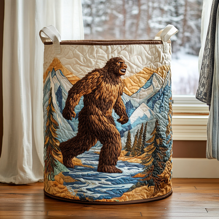Quiltet kurv med broderet bigfoot, der går over en flod foran snedækkede bjerge og graner, brun kant. 7