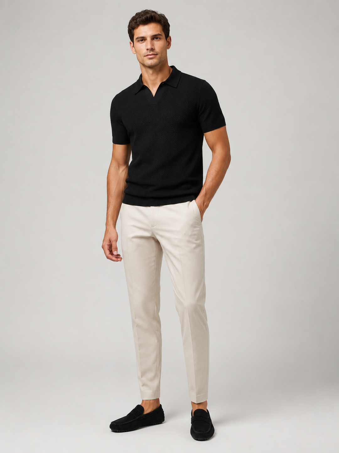 Helfigur af model i sort strikpolo med lyse bukser og sorte loafers 8