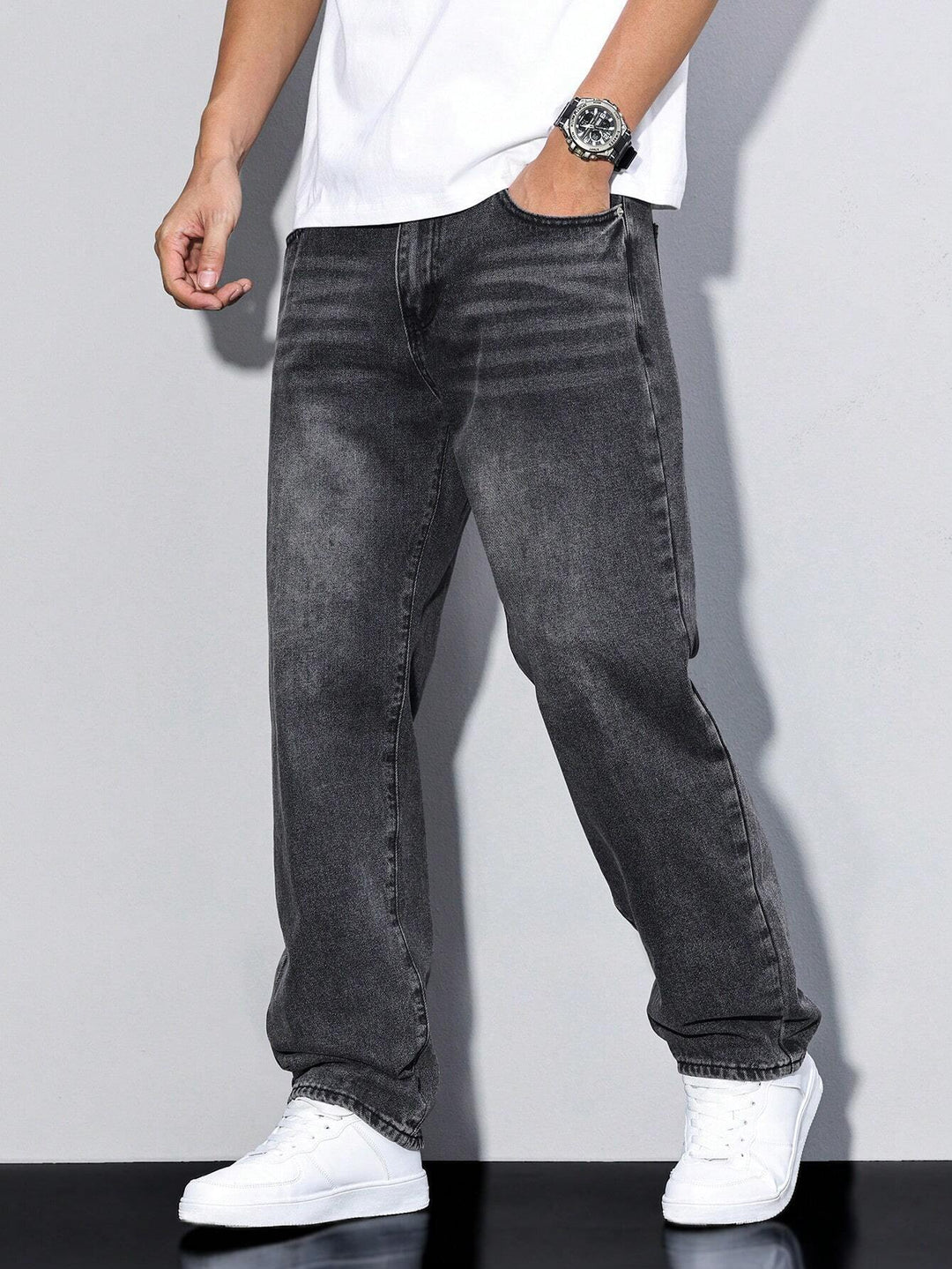 Mørk sortgrå vaskede jeans med lige ben på model, hånd i lommen, hvid t-shirt og hvide sneakers. 6