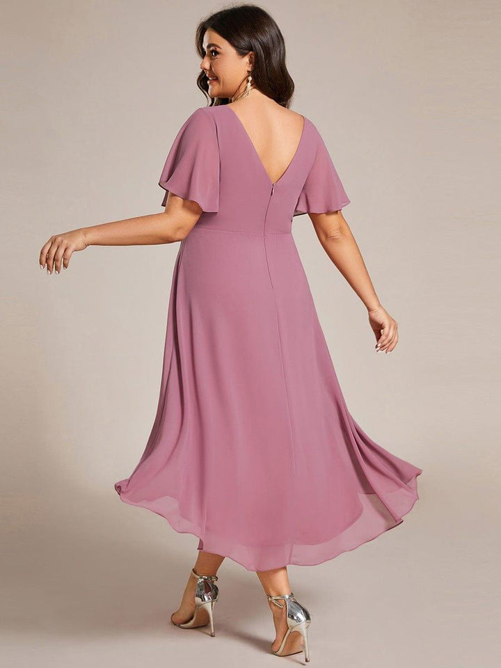 Bagsiden af kjolen i mauve på plus size-model med dyb V-udskæring og lynlås i ryggen. 64