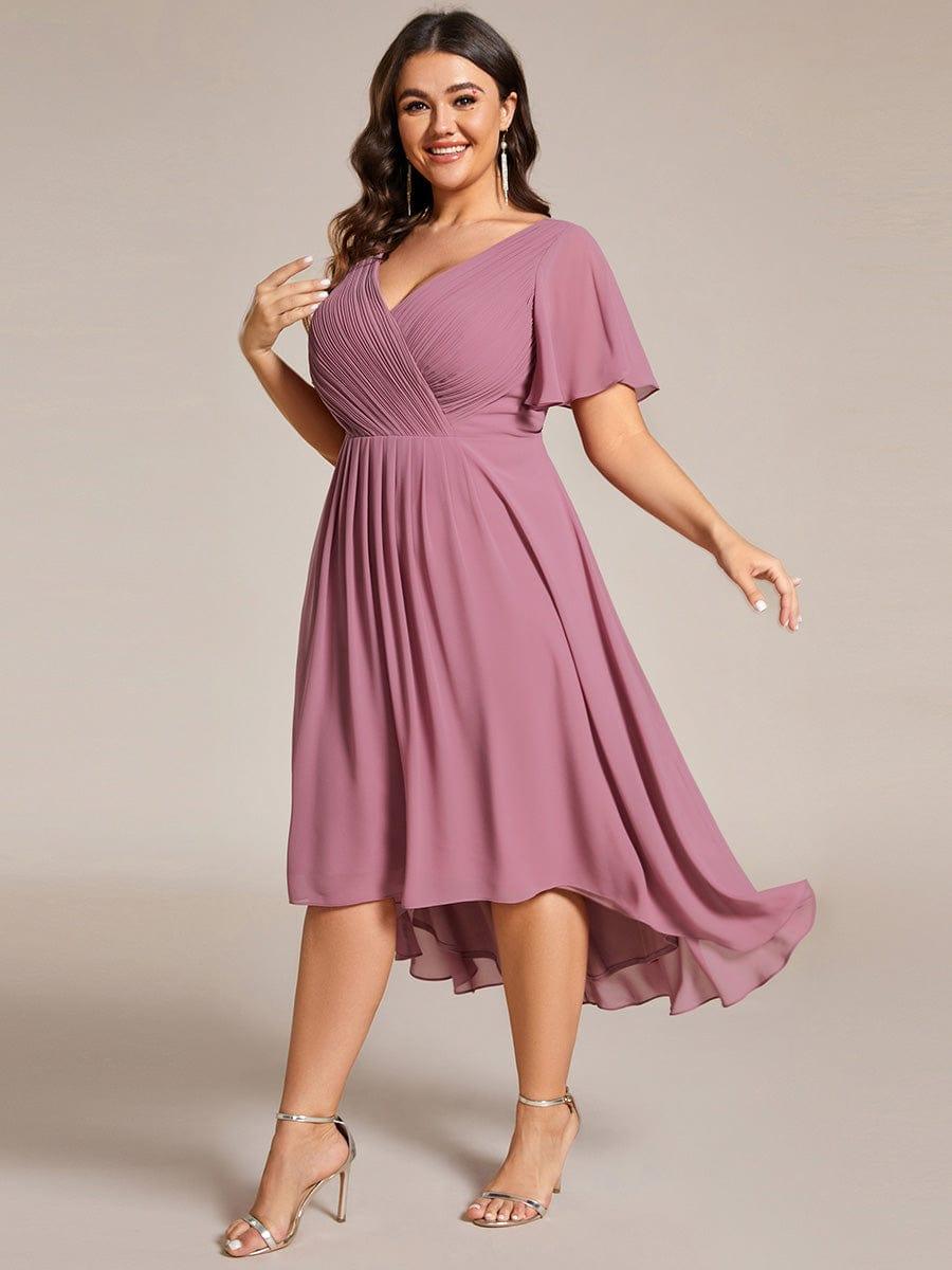 Plus size-model i mauve kjole i bevægelse, set fra siden, så det lette chiffonfald svæver. 67