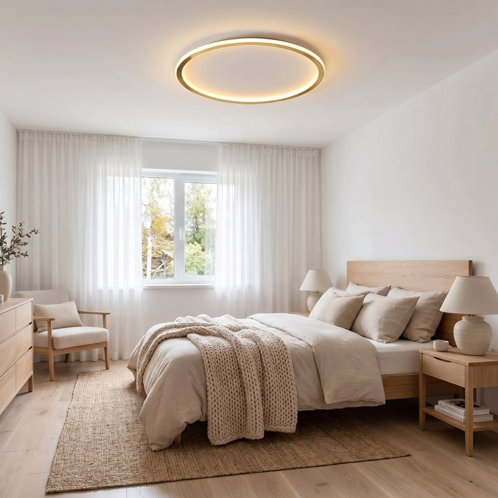 Tændt ringlampe i loftet over en seng i et lyst soveværelse med træmøbler 5
