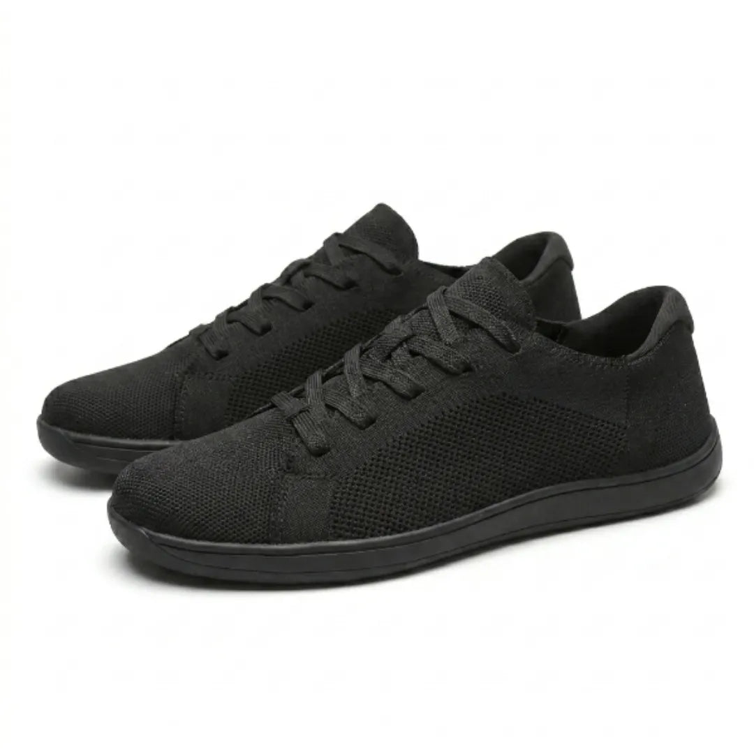 Et par sorte strikmesh-sneakers med snørebånd og flad sål, set på skrå forfra på hvid baggrund. 16