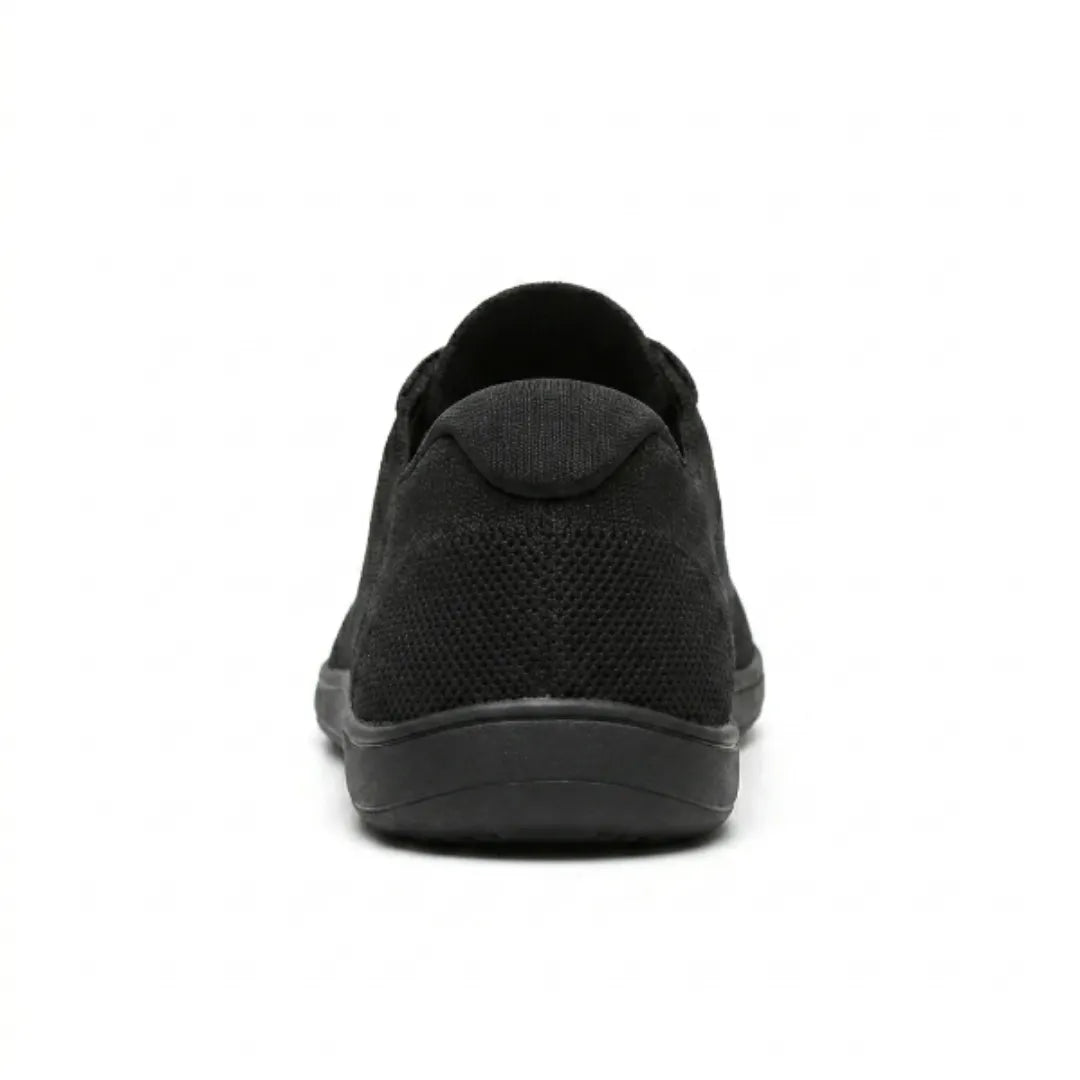 Sort sneaker set bagfra med polstret hælkant, perforeret mesh og flad sort gummisål. 18