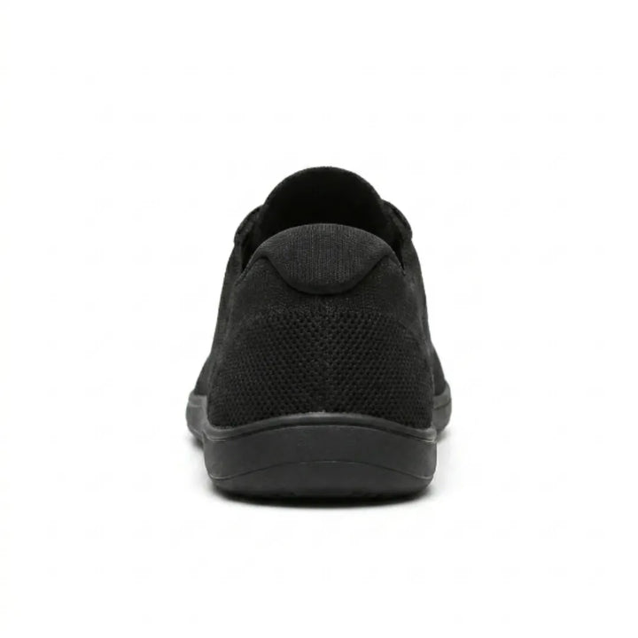 Sort sneaker set bagfra med polstret hælkant, perforeret mesh og flad sort gummisål. 18