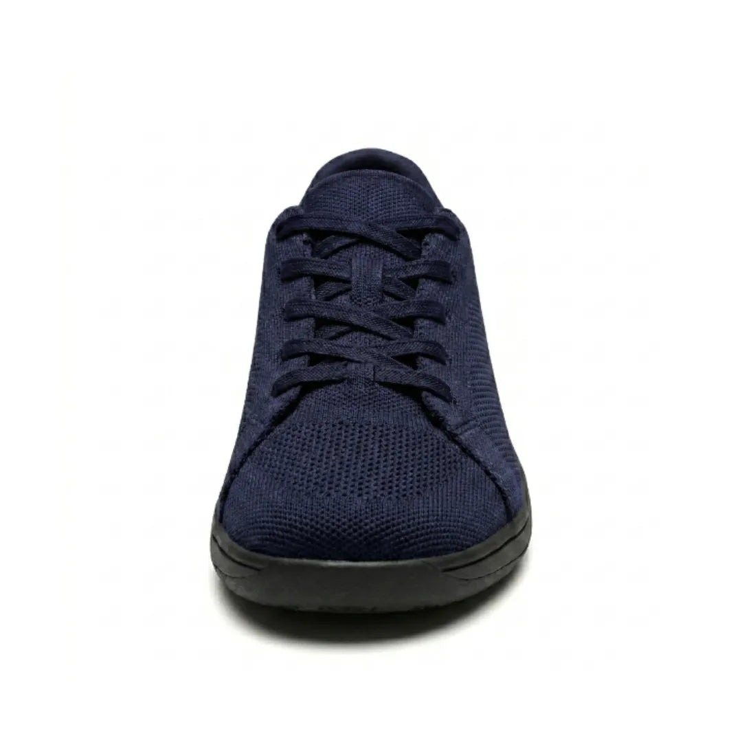 Marineblå mesh-sneaker med sort sål set direkte forfra, så den brede tåboks og snørringen vises. 26