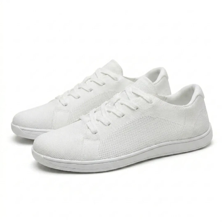 Et par hvide sneakers i åndbart mesh med snørebånd og hvid sål, set på skrå fra siden. 43