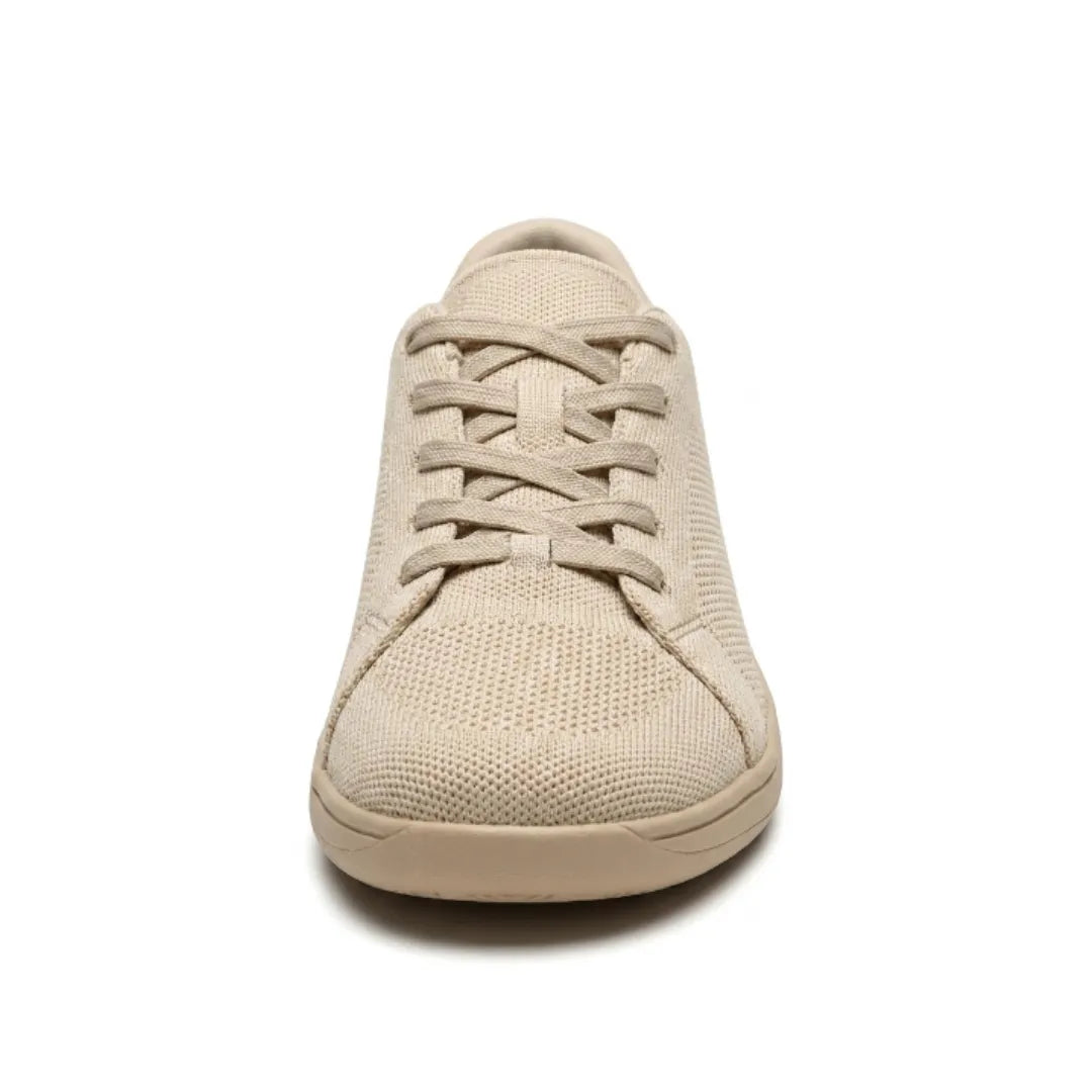 Beige sneaker set lige forfra med krydsede snørebånd, strikket mesh og bred, afrundet tå. 8