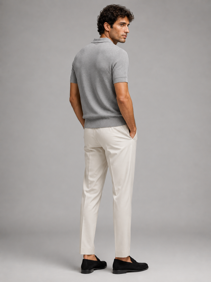 Model i grå strikpolo set bagfra med off-white bukser og sorte loafers, ser til siden 29