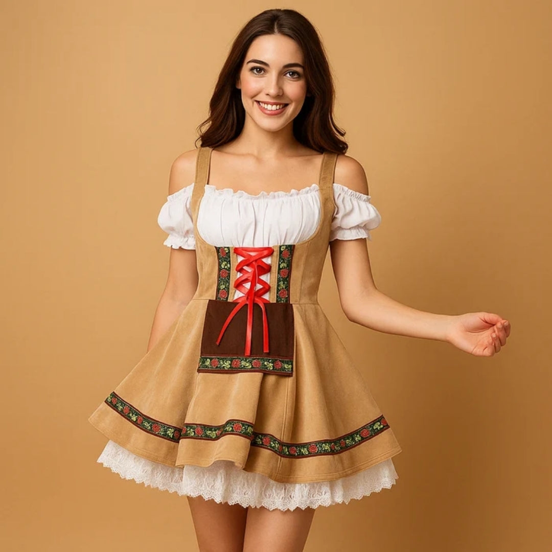 Smilende model i sandfarvet dirndl med rød snøring, brunt forklæde, blomsterbort og hvid underkjole af blonde, der titter frem. 3