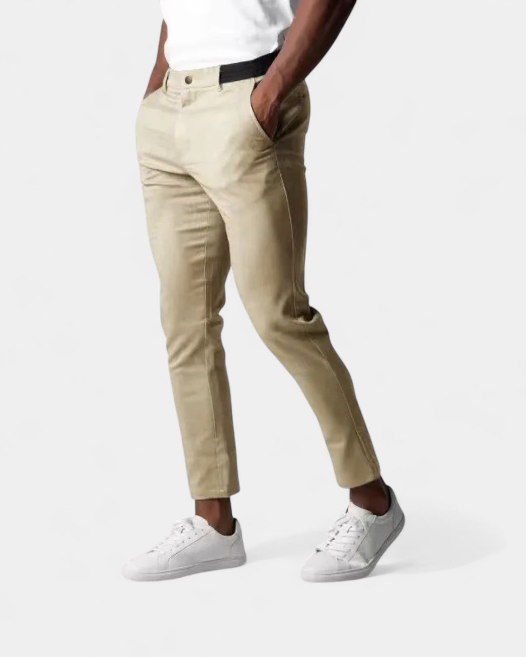 Model i beige smalle bukser med sort elastisk linning set fra siden, med hvide sneakers 3