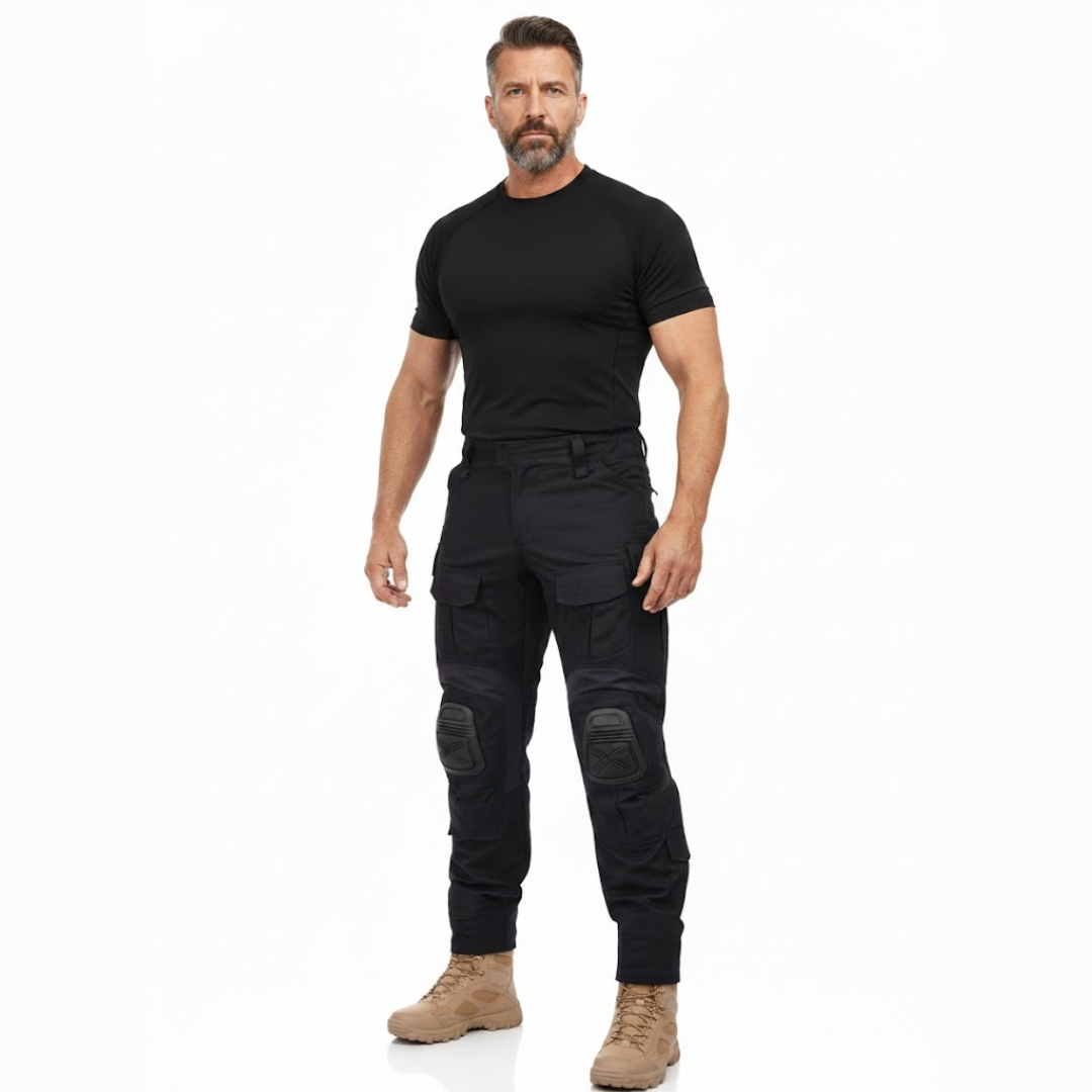 Fuld figur af mand i sort T-shirt og beige støvler iført de sorte cargobukser med lårlommer og knæbeskyttere. 7