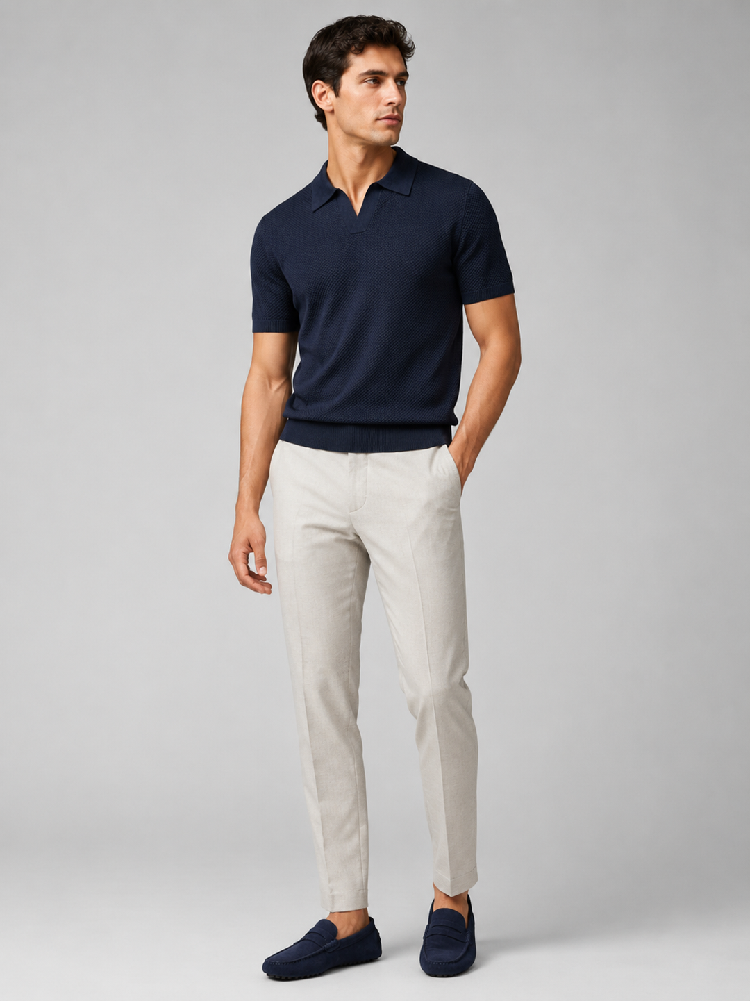 Helfigur af model i marineblå strikpolo med lyse bukser og marineblå ruskindsloafers, set forfra 37