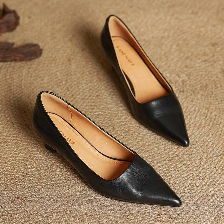 Et par sorte pumps set ovenfra på flettet underlag med lyst foer 16