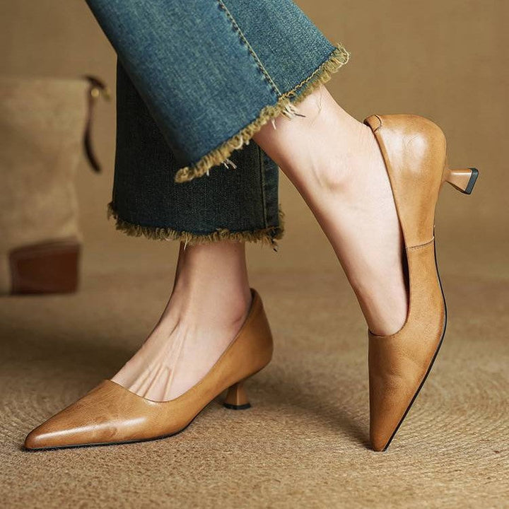 Model i jeans med frynsede ben og lysebrune pumps, den ene fod løftet så hælen ses 3