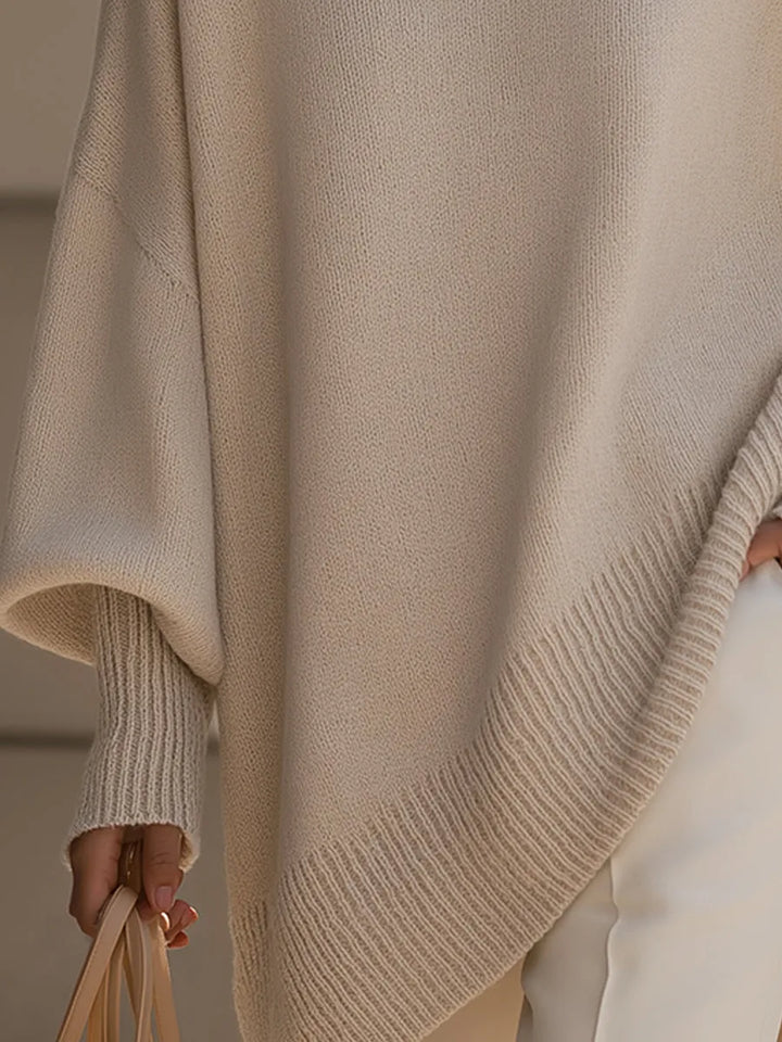Detalje af den skrå ribkant forneden og de ribstrikkede ærmeopslag på den beige strikbluse. 3