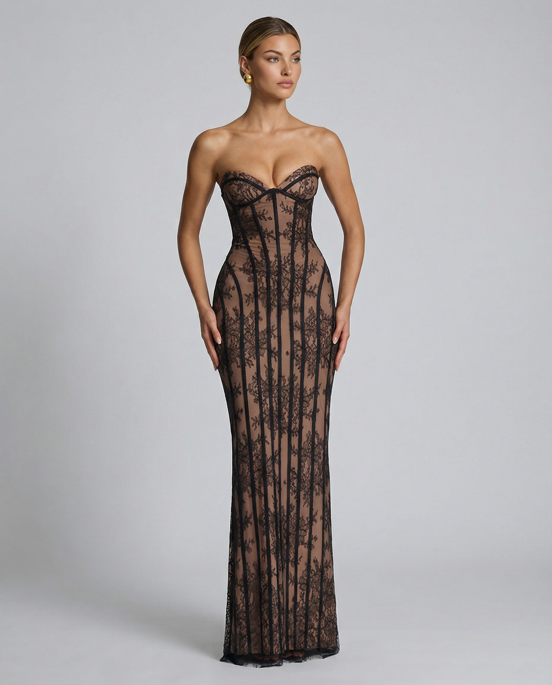 Model i sort blondekjole med hjerteformet bustier, ansigtet drejet til siden og armene langs kroppen. 8