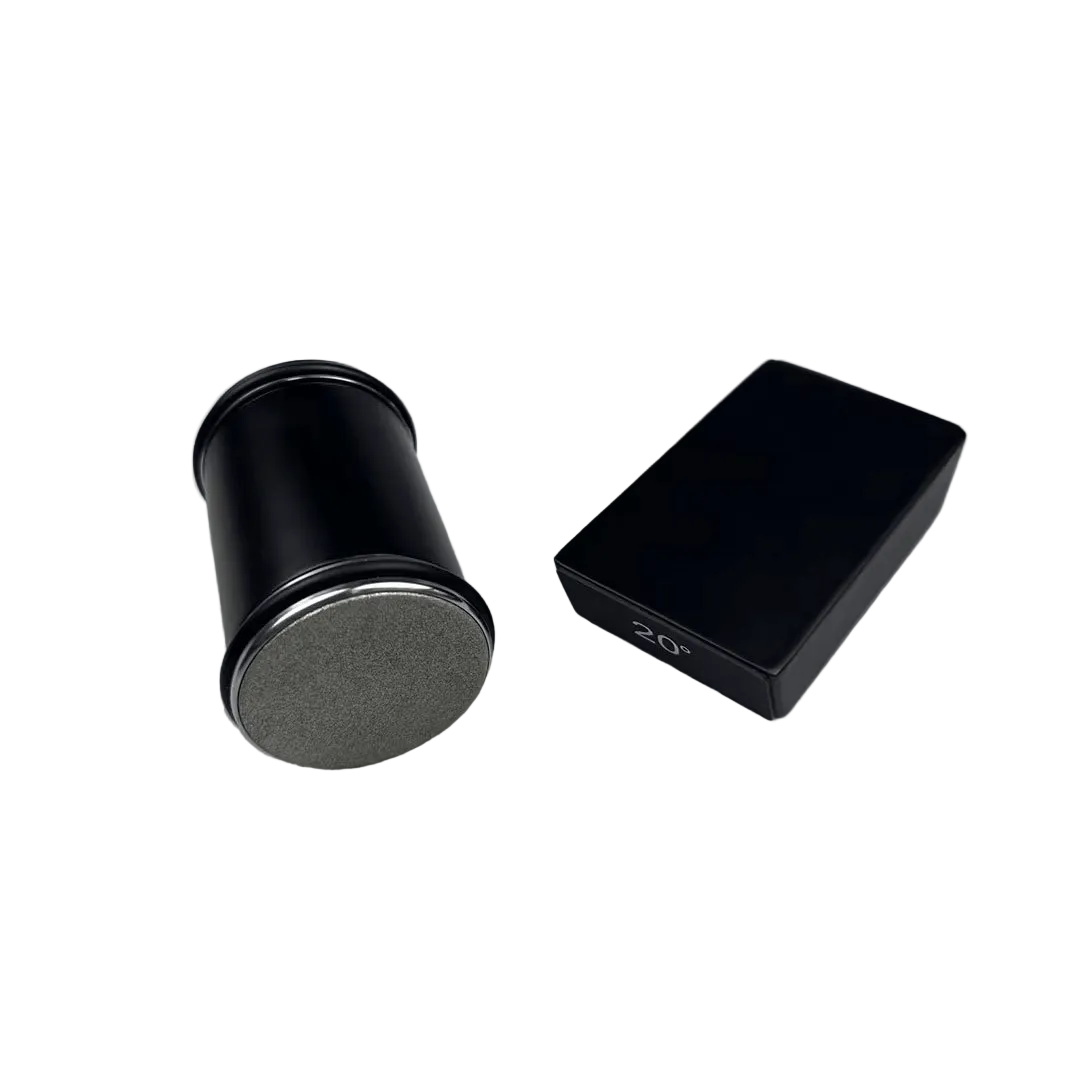 Sort cylinder med diamantbelagt slibeflade og en sort vinkelguide-blok ved siden af, set på hvid baggrund. 1