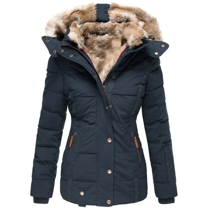 Mørkeblå quiltet parka med tyk pelsforet hætte og lynlåslommer med brune lædertrækkere, set forfra. 5