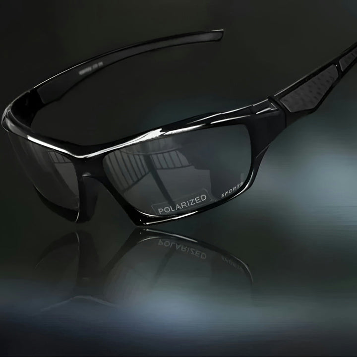 Sportsbrille helt i sort med mørke glas, set skråt fra siden på mørk baggrund 10