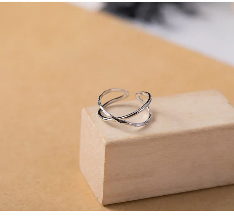 Silberner offener Ring, minimalistisches Design, auf Holzblock, Schmuck für Damen.