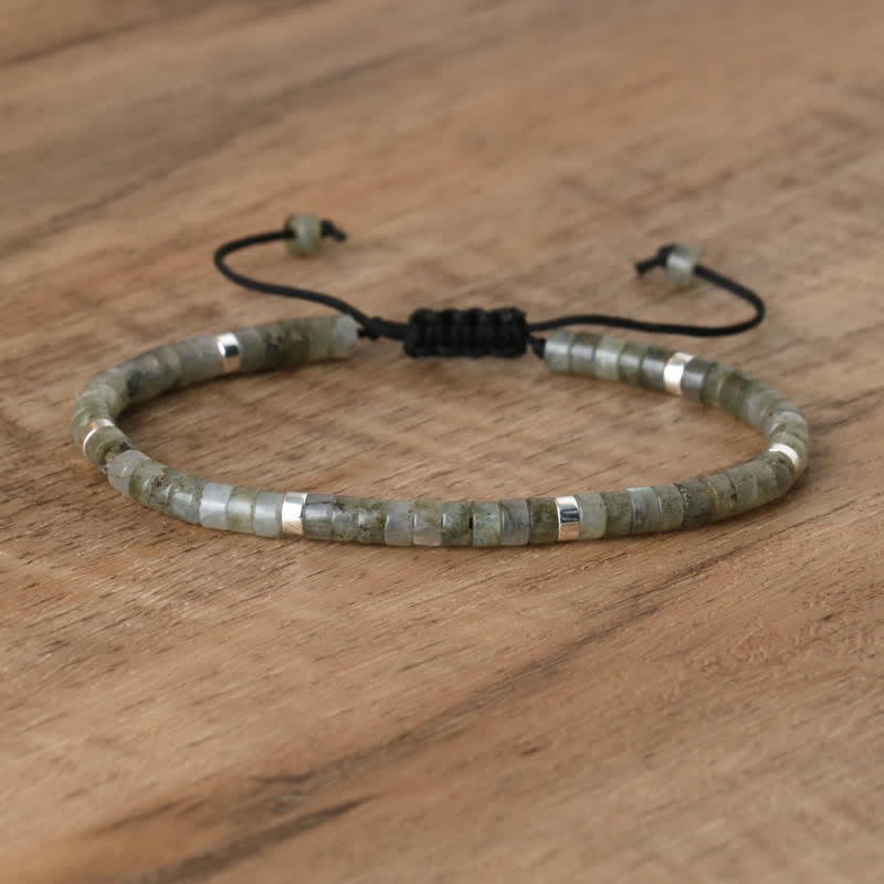 Armband aus grünem Labradorit mit verstellbarem Verschluss auf Holzoberfläche.
