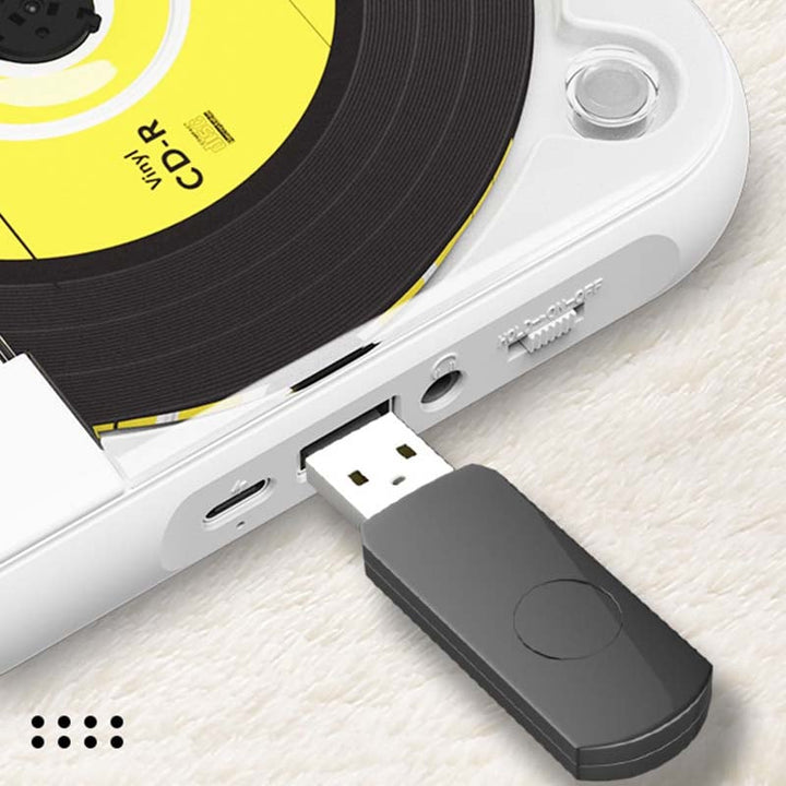 Nærbillede af den hvide afspillers side med en sort USB-stick sat i USB-porten, ved siden af USB-C-porten og hovedtelefonudgangen. 9