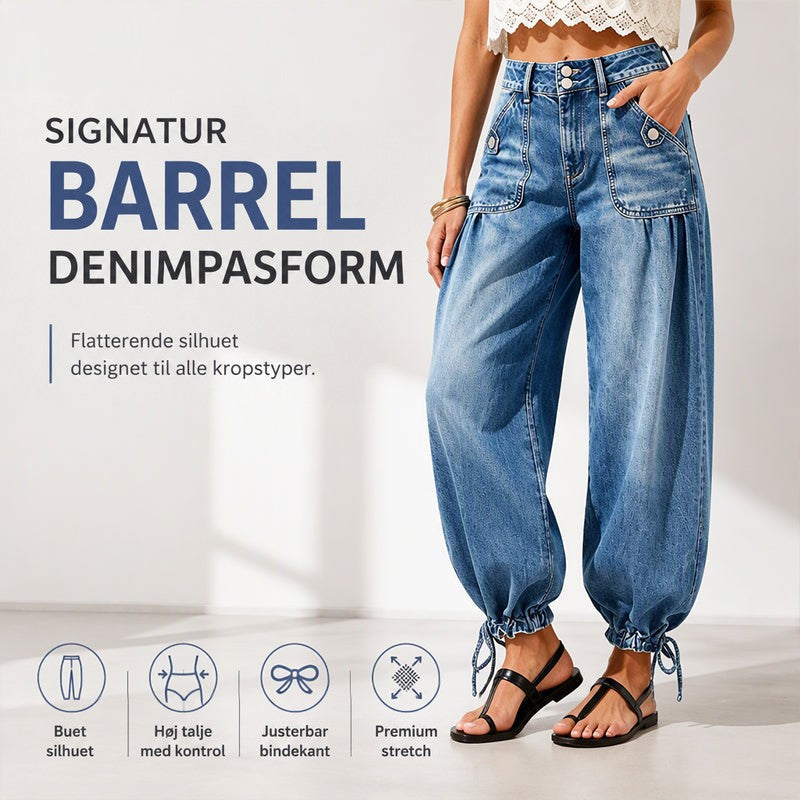 Model i blå tøndejeans med lommer og bindebånd ved sømmen, med ikoner over tøndeform, høj talje, justerbar søm og stretch. 1