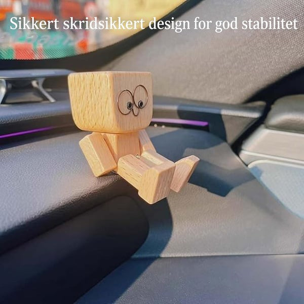 Træfigur med runde briller-øjne sidder på bilens instrumentbrædt, med tekst om skridsikkert design for stabilitet. 12