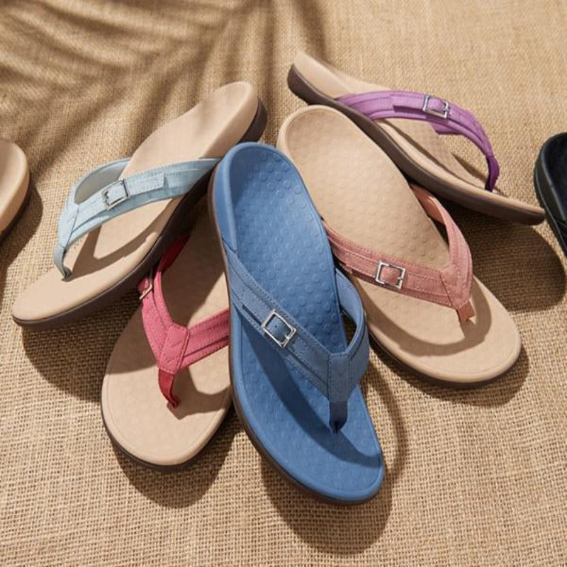 Flere sandaler i blå, lyseblå, rød, pink og lilla liggende på vævet underlag 11