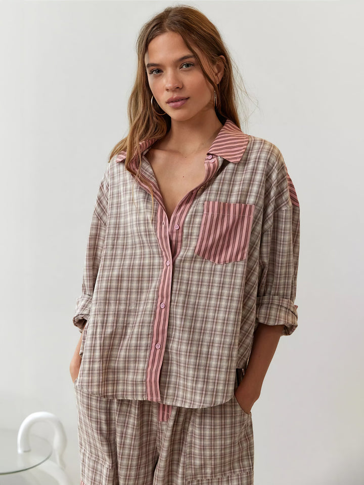Model set forfra i ternet pyjamasskjorte med lyserød stribet krave, knaplukning og brystlomme, ærmerne rullet op og hænderne i lommerne. 4