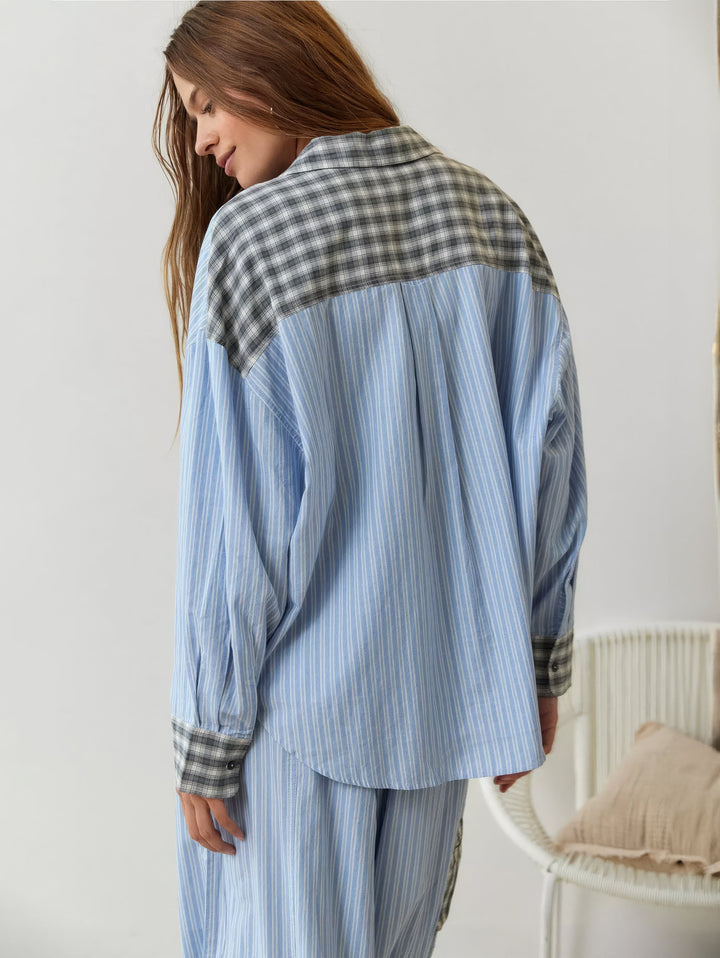 Model set bagfra og let fra siden i blå stribet pyjamasskjorte med grå ternet overdel på ryggen og ternede manchetter. 9