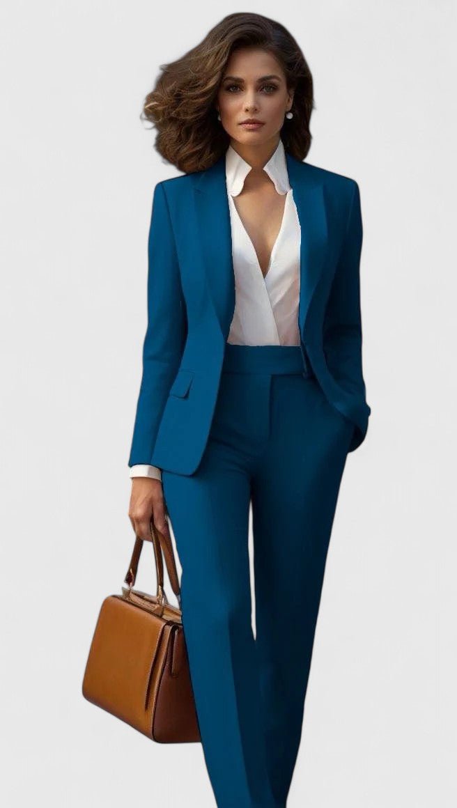 Model i blåt sæt med blazer og bukser med lige ben, hvid skjorte og brun læderagtig håndtaske. 2