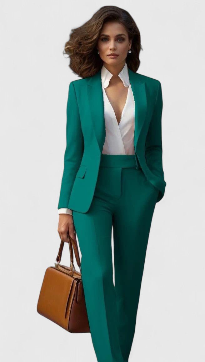 Model i grønt sæt med blazer og bukser med lige ben, hvid skjorte og brun håndtaske i hånden. 4