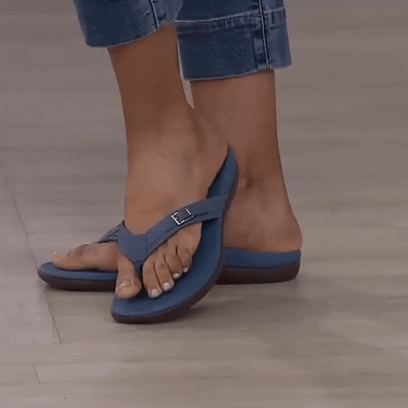 Model i cuffede jeans går i blå sandal med spænde og tåsteg på gråt gulv 2