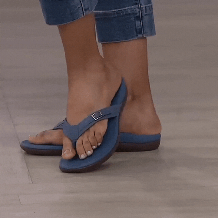 Model i cuffede jeans går i blå sandal med spænde og tåsteg på gråt gulv 2
