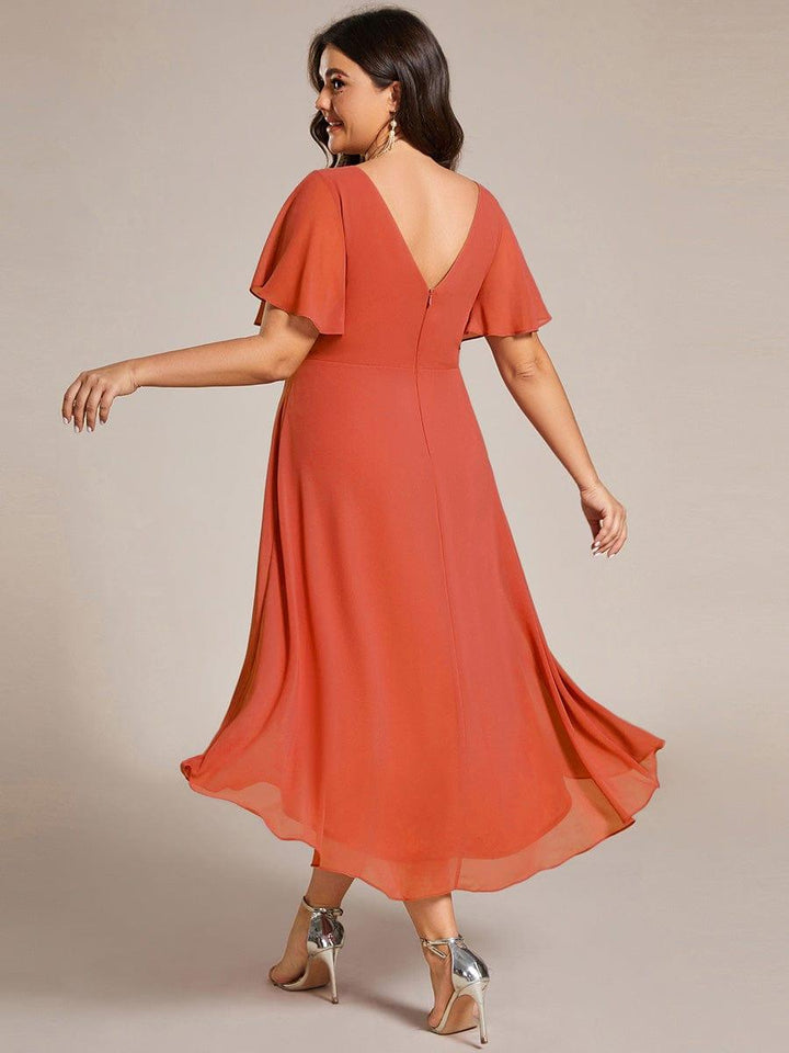 Rustorange chiffonkjole set bagfra på plus size-model, med V-udskæring i ryggen, lynlås og bølgende fald. 98
