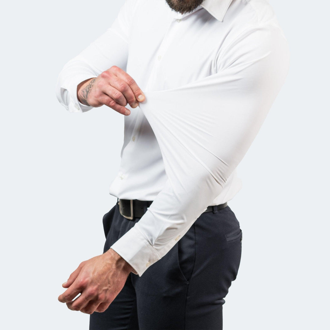 Hvid langærmet skjorte på en model, der trækker i ærmet for at vise, hvor meget stoffet kan strækkes. 4