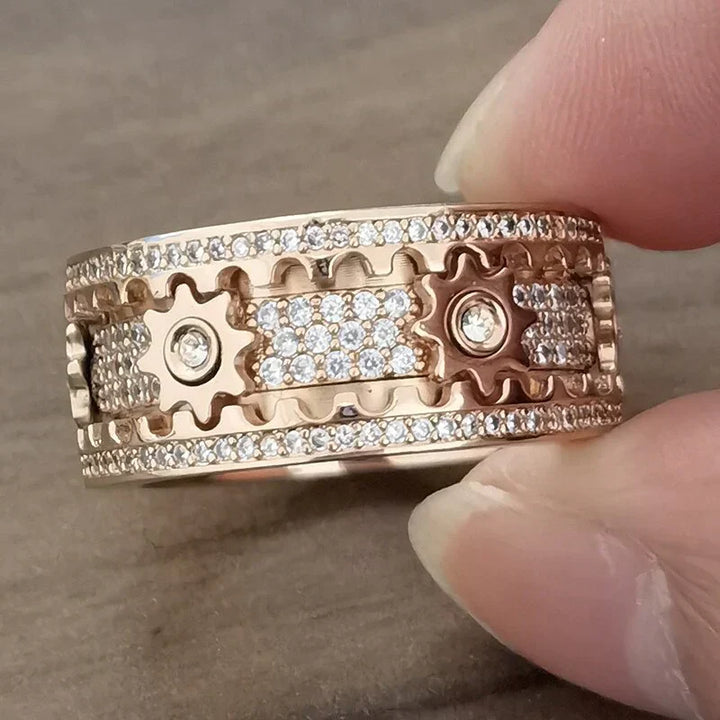 Roségoldener Ring mit Zahnraddesign und Diamantakzenten, luxuriöser Schmuck für Damen.
